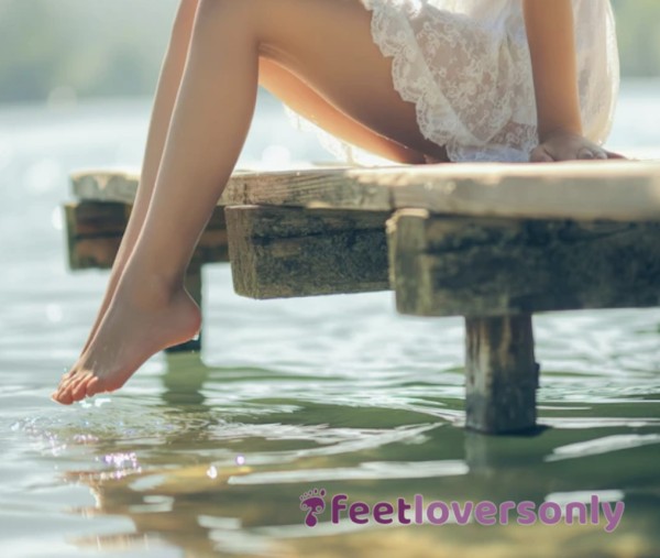 Graceful Legs And Bare Feet On Sunlit Dock, Touching Shimmering Water In A Lace Dress