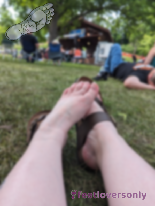 Top View Of Feet At Festival, Partially Wearing Sandal